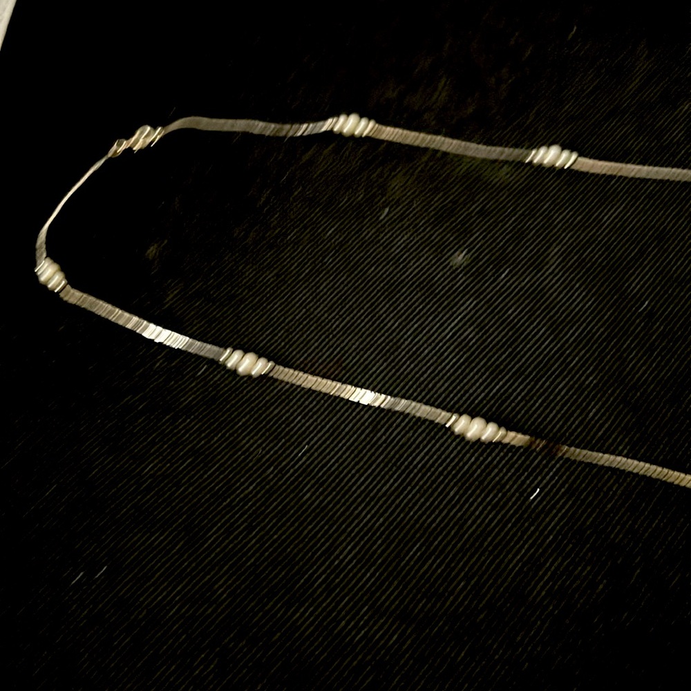 Then silver necklace with little white pearls very long